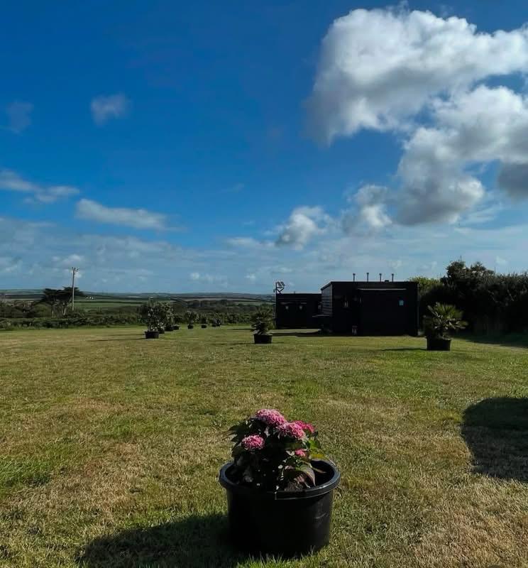 The field with the toilet and shower block in the background